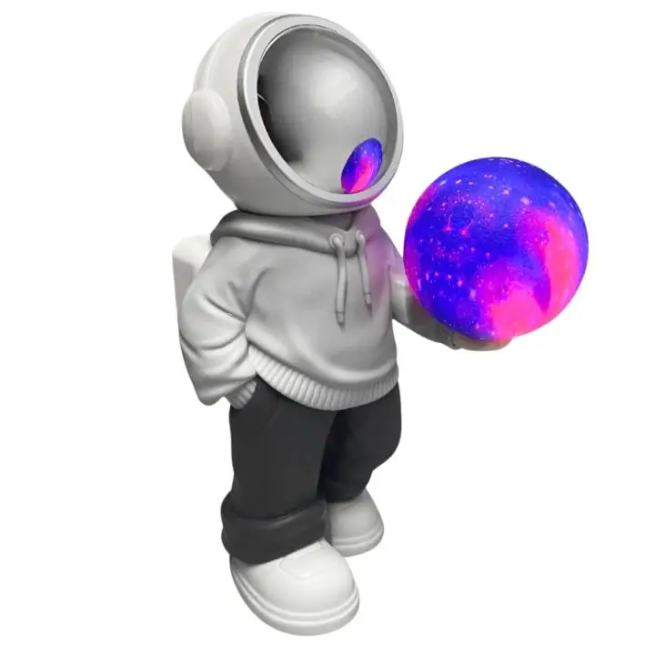 Proyector de luces LED con forma de astronauta sosteniendo una esfera brillante de galaxia de colores.